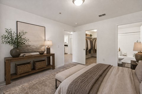 A bedroom with a large bed and a painting on the wall.