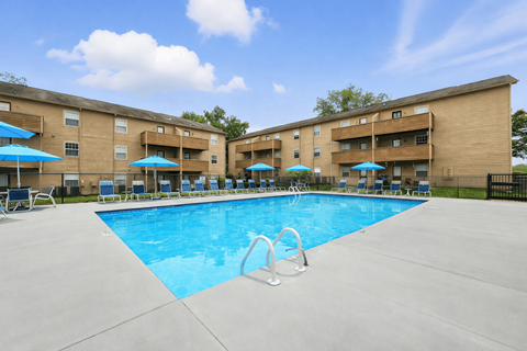 A large swimming pool in front of apartment buildings.