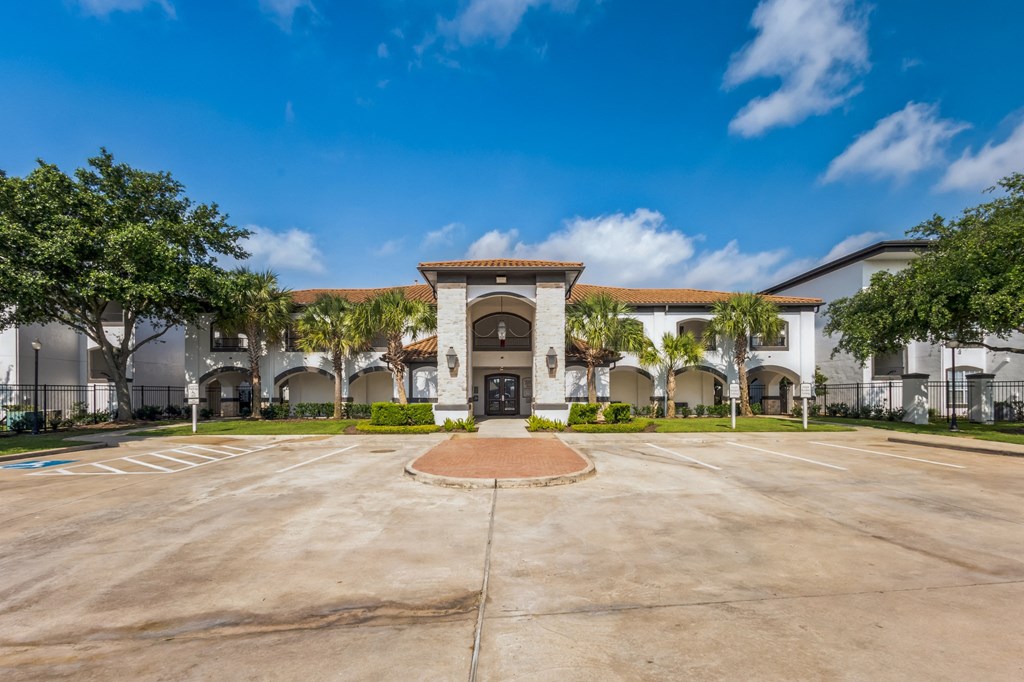 a large parking lot in front of a building with palm trees