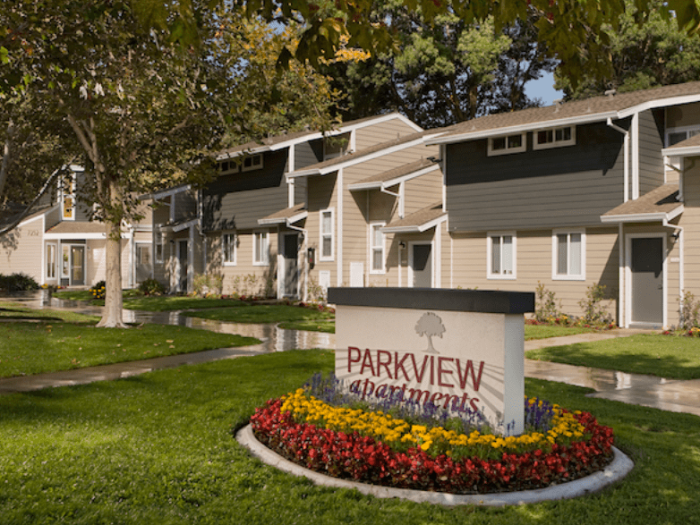 a parkview apartments sign in front of a row of houses
