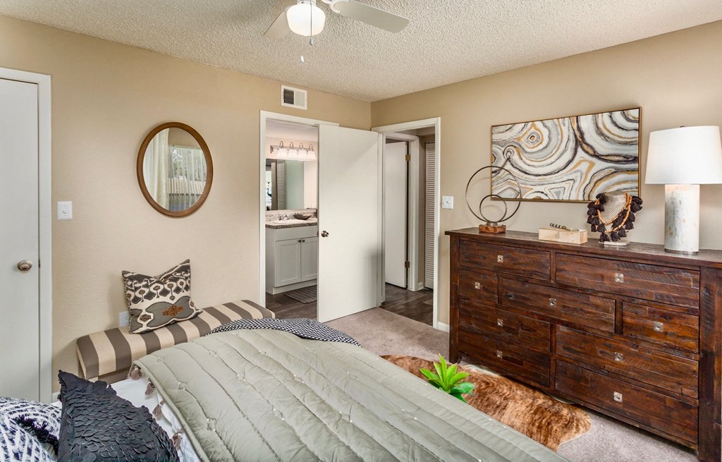 a bedroom with a bed and a dresser and a bathroom