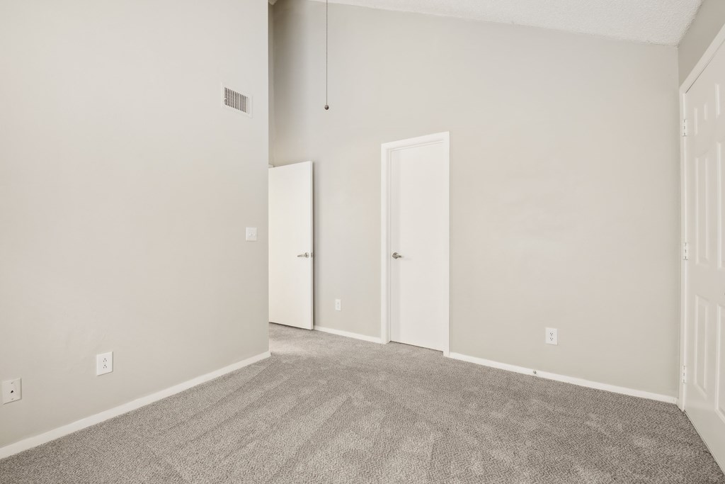 A room with two doors and a carpeted floor.