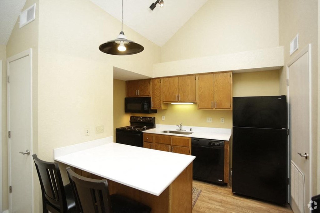 a kitchen with a white counter top and black appliances