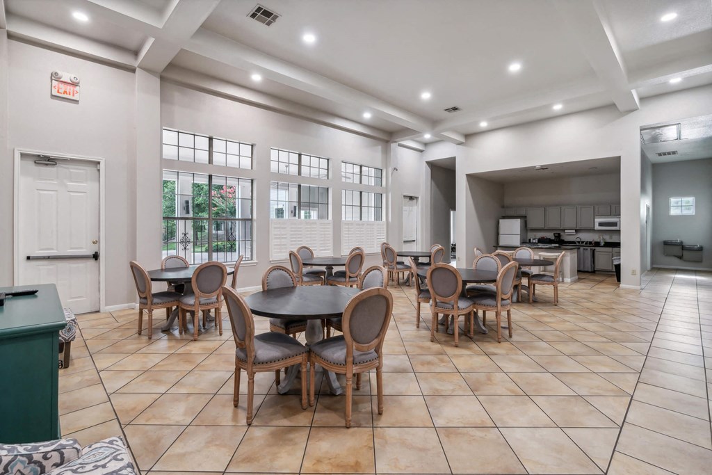 a dining area with tables and chairs and a kitchen in the background at St. Augustine Estate, Dallas, Texas