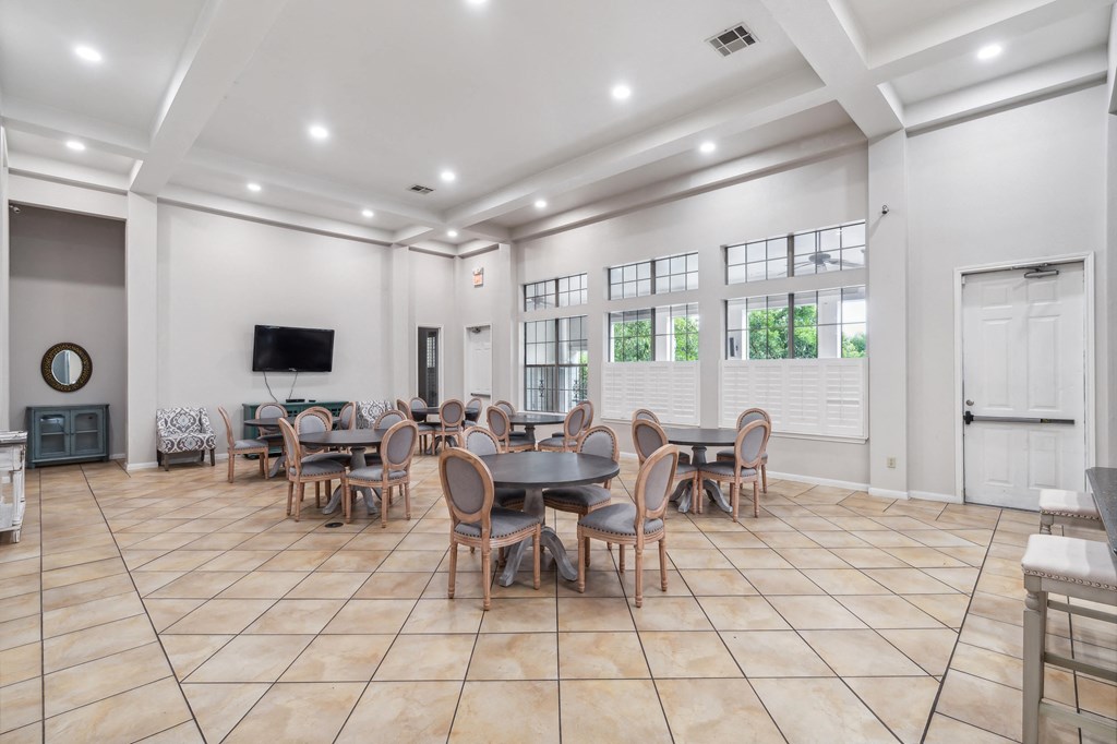 the dining room has a large table and chairs and a tv