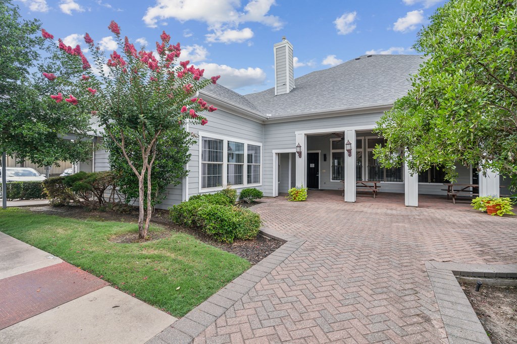 the front of a house with a brick walkway and a porch