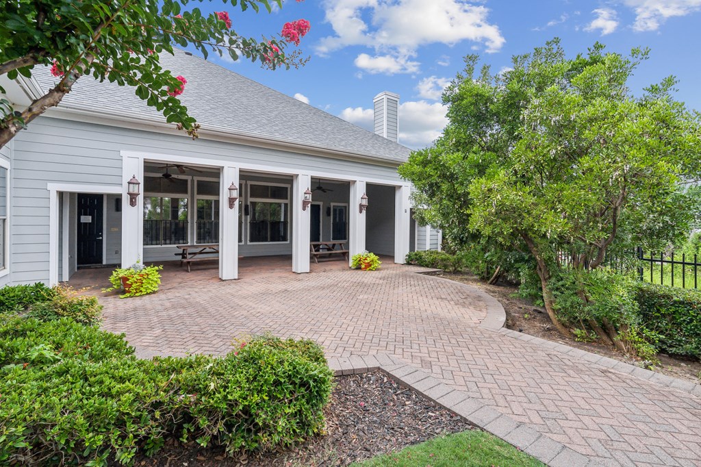 the front of a house with a brick walkway and a porch