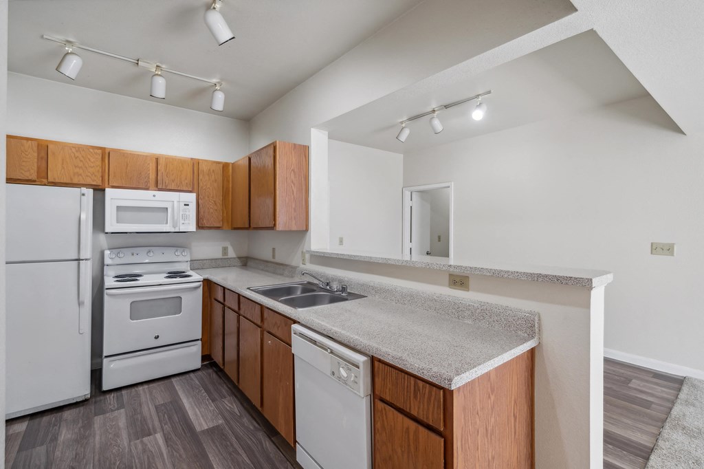 a kitchen with white appliances and a granite counter top