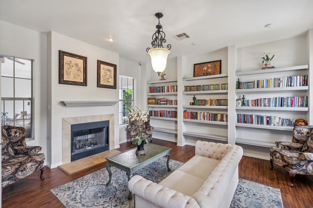 a living room with a fireplace and bookshelves
