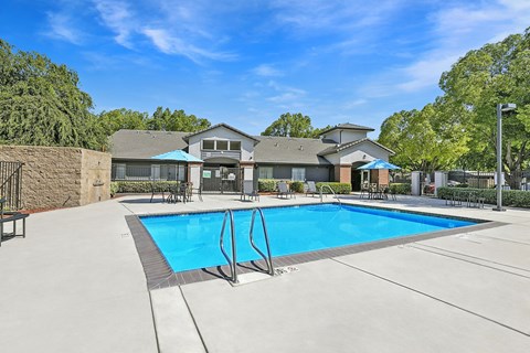 A swimming pool in a residential area with a house in the background.