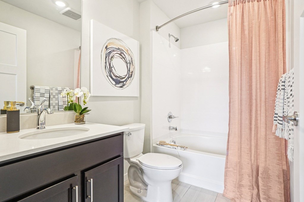 A bathroom with a toilet, sink, and shower. at Connect at First Creek Apartments, Denver, CO
