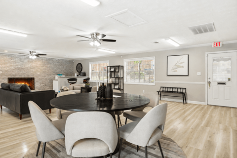 A modern dining room with a black table and white chairs.