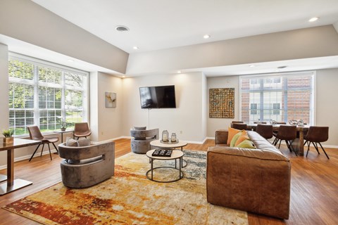 a living room with a couch and chairs and a tv