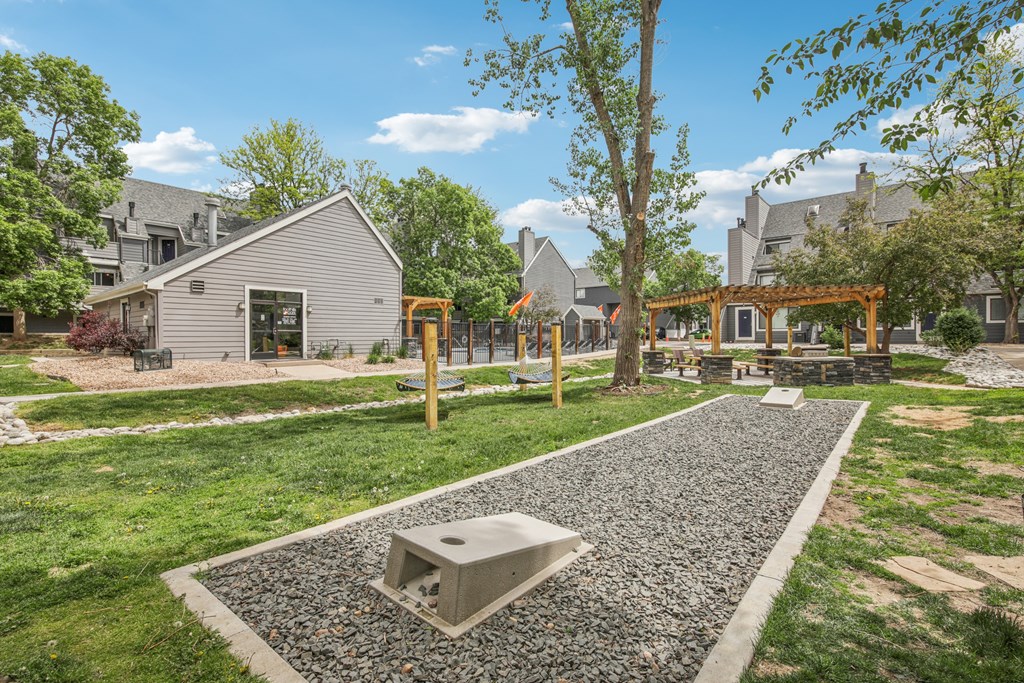 A playground with a slide and a swing set in a grassy area.