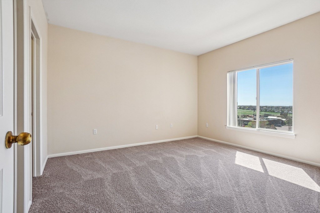 A room with a carpeted floor, a door, and a window. at Stetson Meadows Apartments, Colorado, 80922