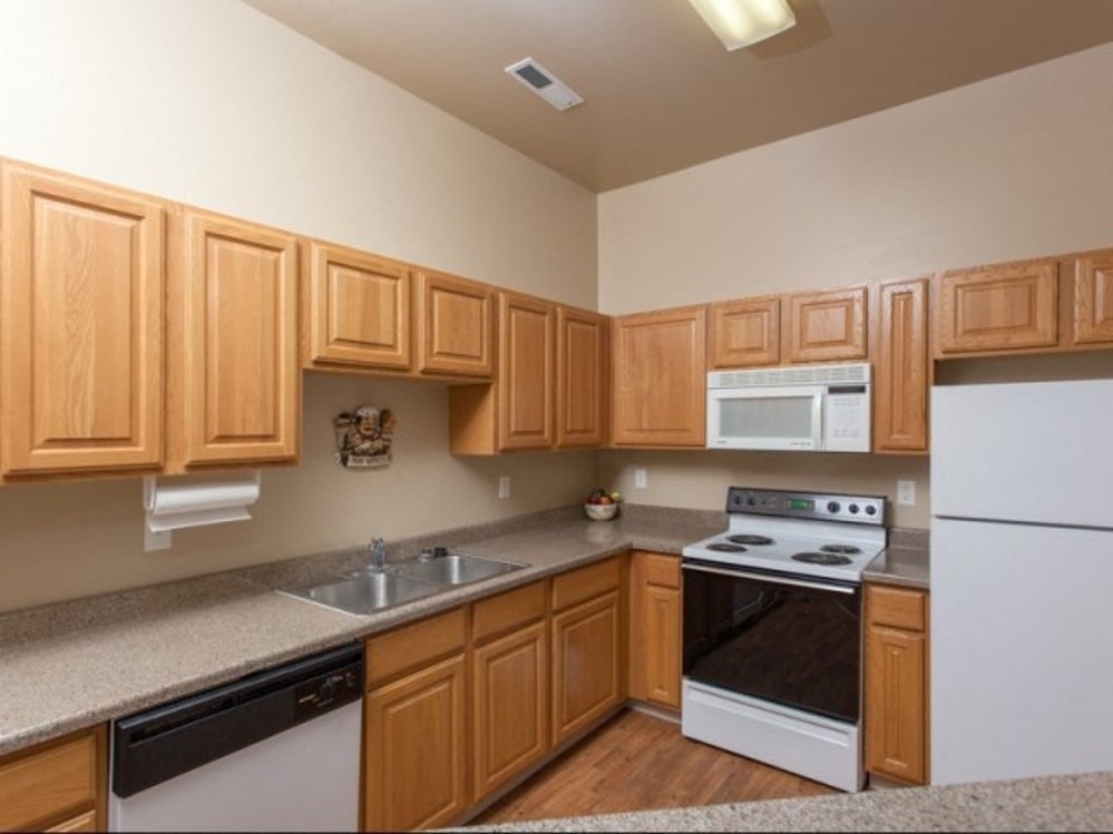 a kitchen with wooden cabinets and white appliances