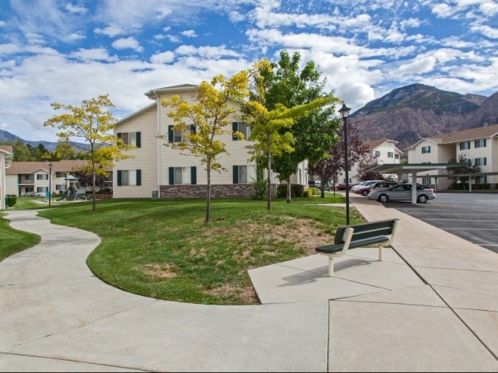 a park bench on a sidewalk in front of a building
