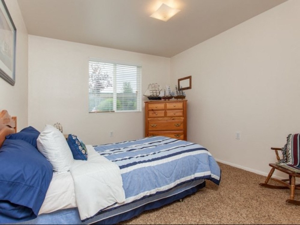a bedroom with a bed and a dresser and a window