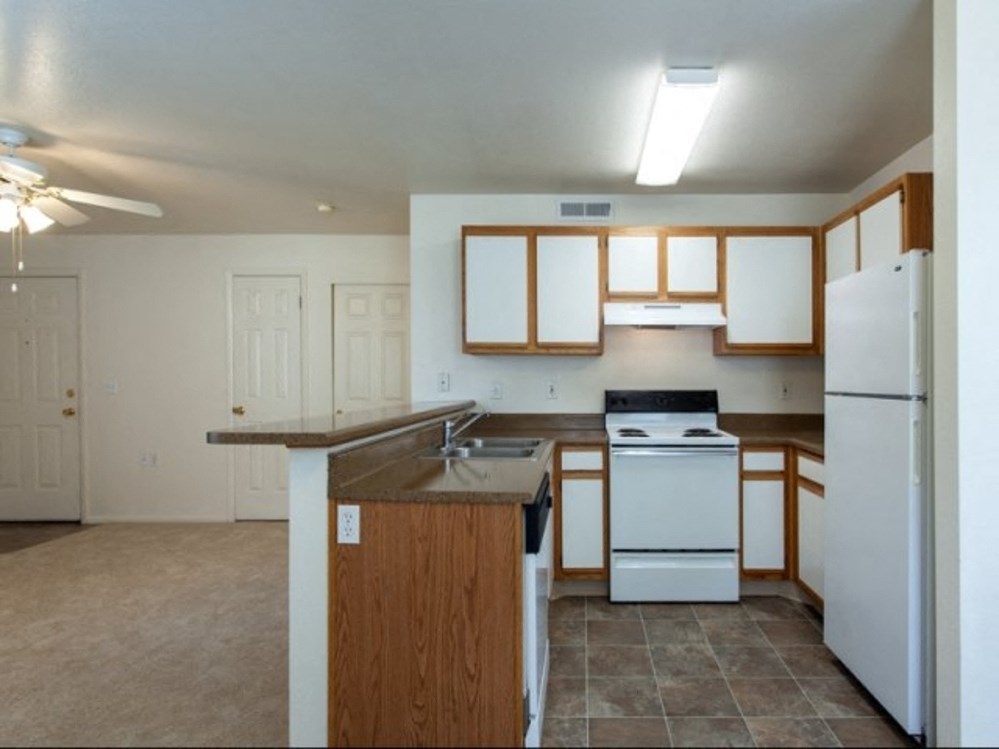 an empty kitchen with a stove refrigerator and sink