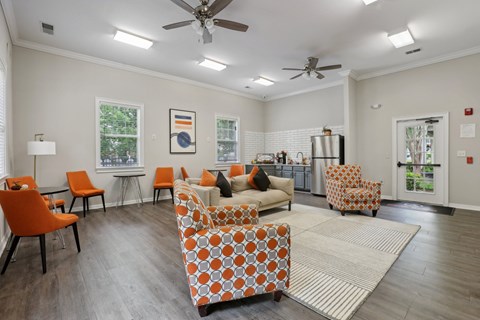 A living room with orange chairs and a patterned sofa.