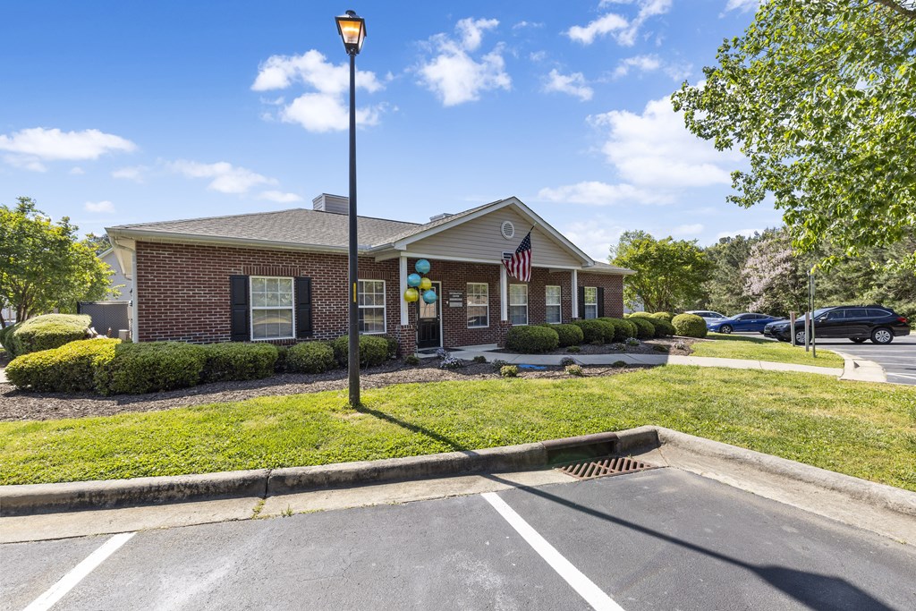 the front of a brick house with a lawn and a street light