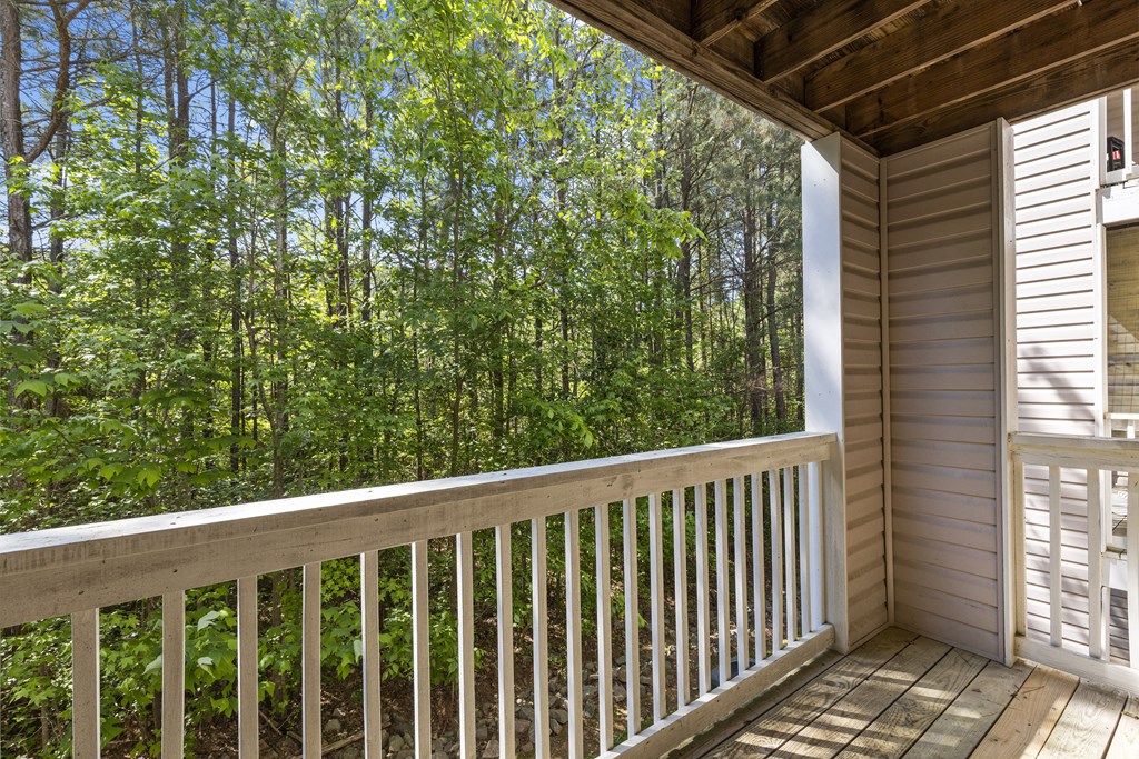 a view of the woods from the balcony of a cabin