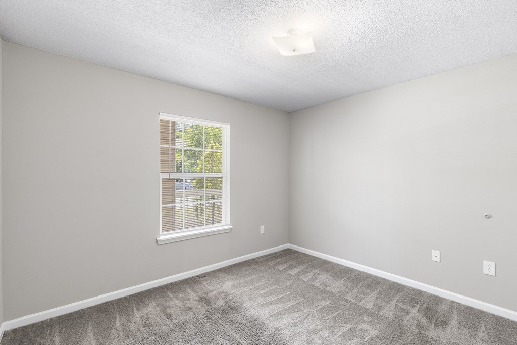 an empty room with carpet and a window