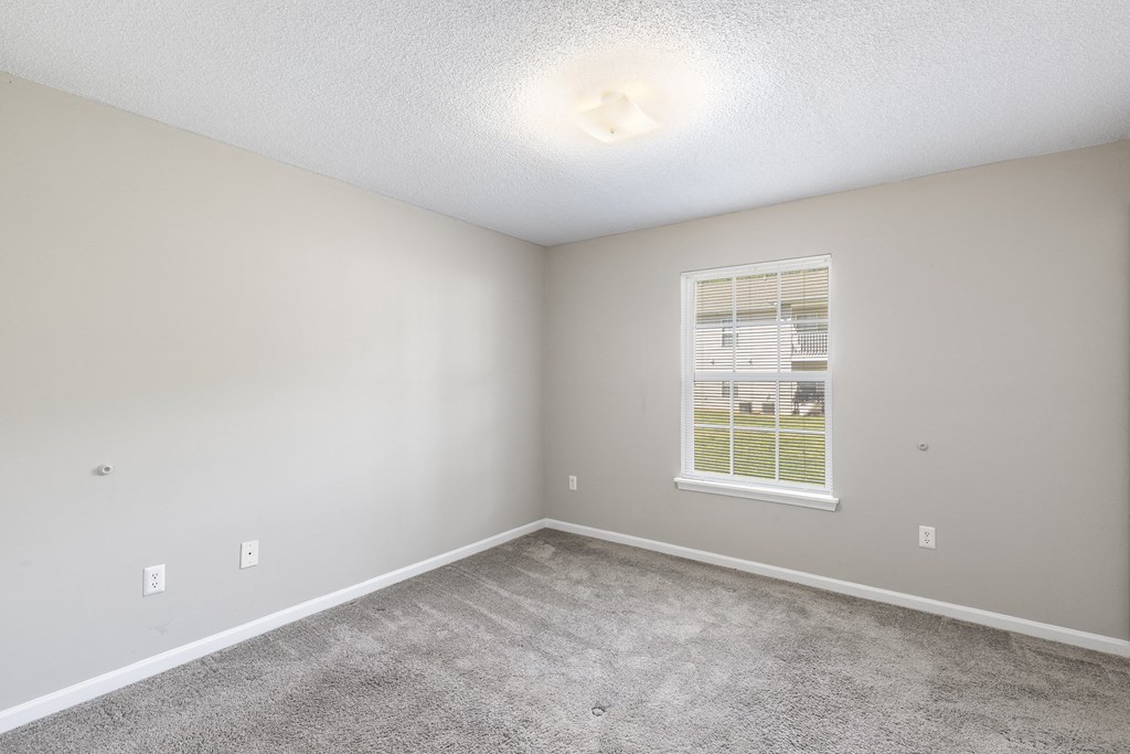 an empty room with carpet and a window