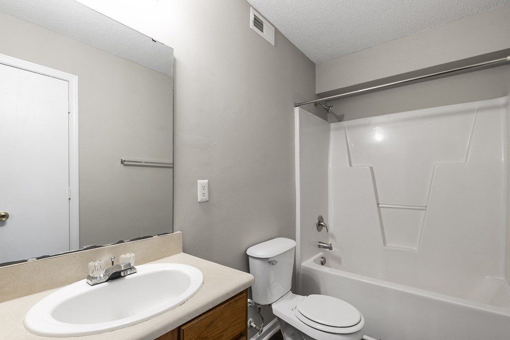 an empty bathroom with a sink toilet and shower