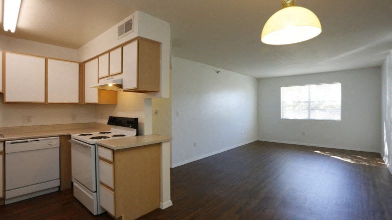 an empty kitchen and living room with a stove