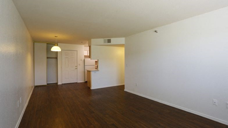 an empty living room with white walls and wood floors