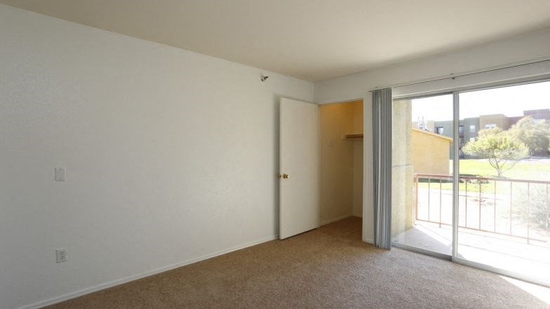 a living room with a sliding glass door to a balcony