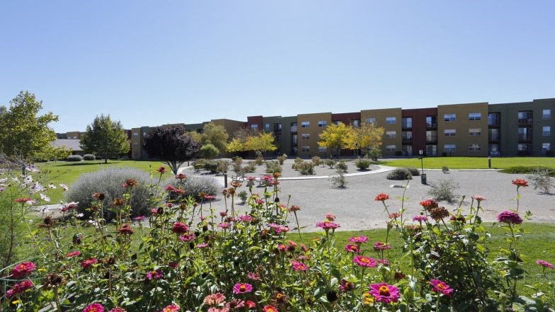 a park with flowers in front of a building