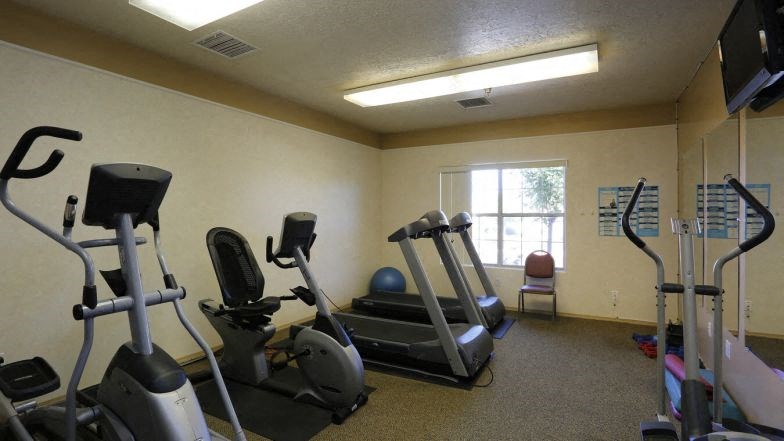 a gym with various exercise equipment and a window