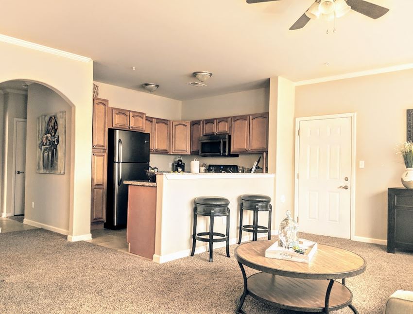 a kitchen and living room with a bar and a refrigerator