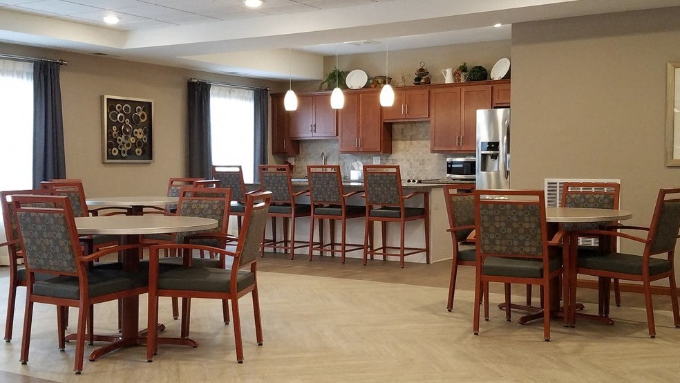 a dining room with tables and chairs and a kitchen