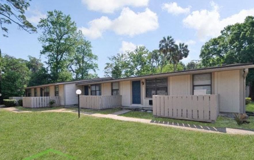 a white house with a yard and a white fence