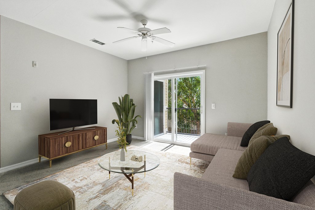 A living room with a grey couch, a coffee table, and a flat screen TV.