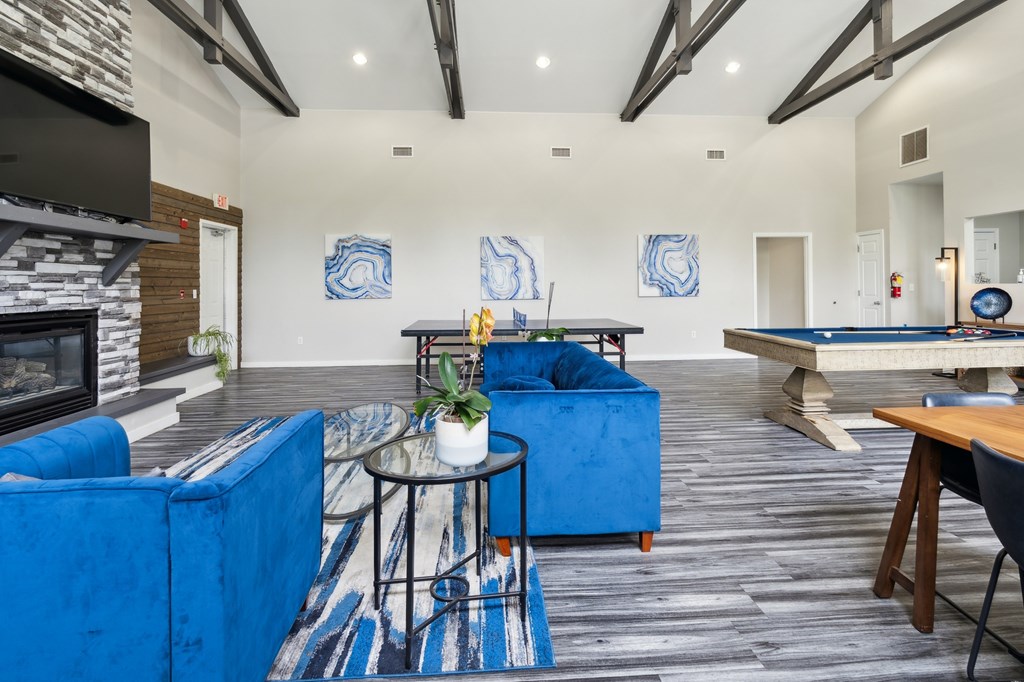 a living room with blue couches and a pool table