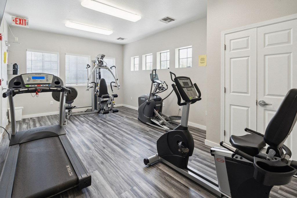 a gym with cardio machines and other exercise equipment at the belgard apartments