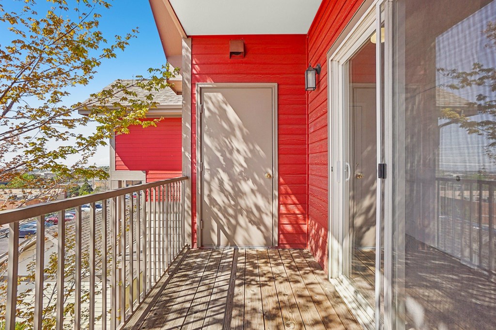 A red house with a white door and a balcony. at Stetson Meadows Apartments, Colorado Springs, Colorado