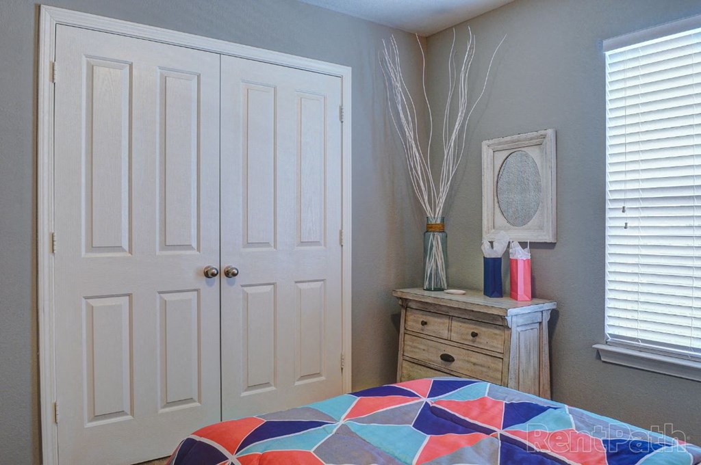 a bedroom with a bed and a dresser and a closet