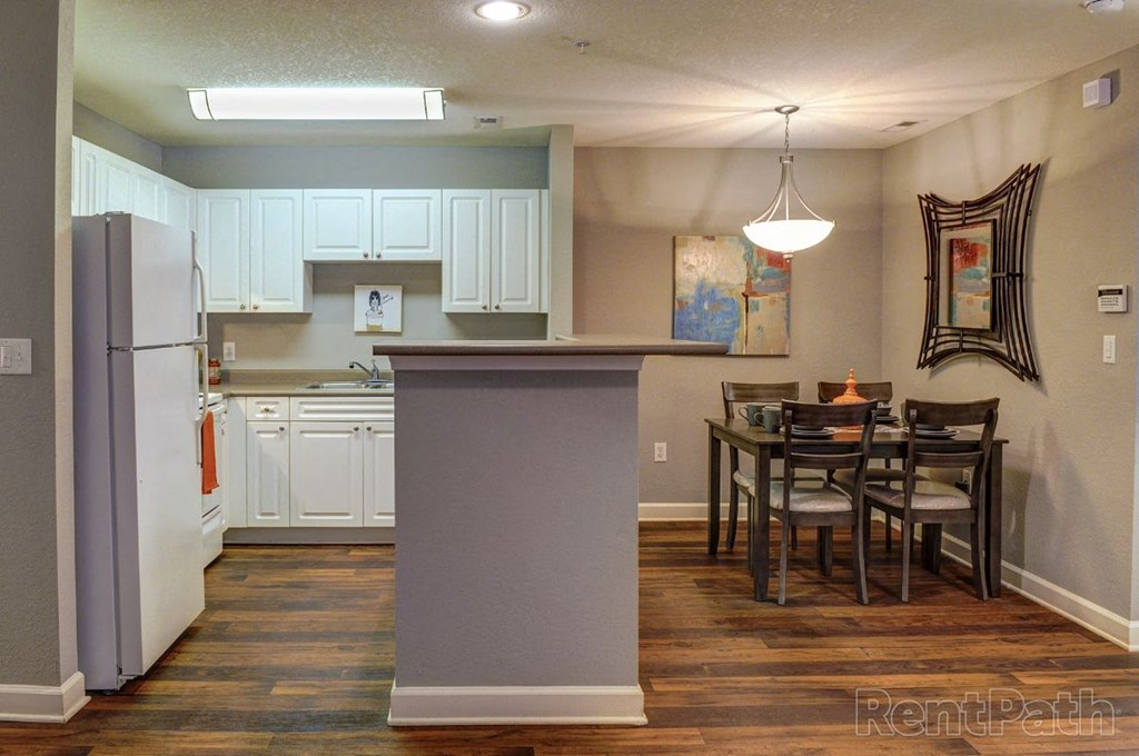a kitchen and dining area with a refrigerator and a table