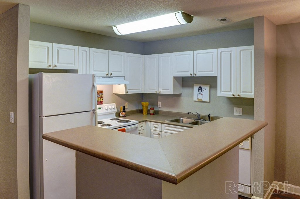 a kitchen with white cabinets and a refrigerator
