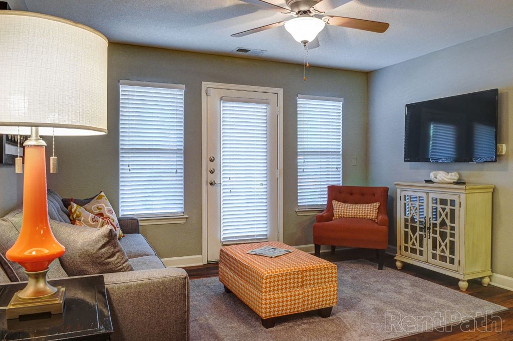 a living room with a couch and a chair and a ceiling fan