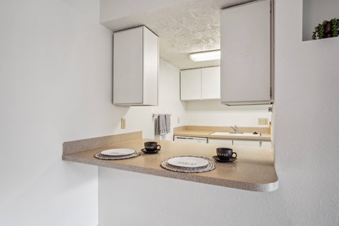 A kitchen with a countertop and cabinets reflected in a mirror.