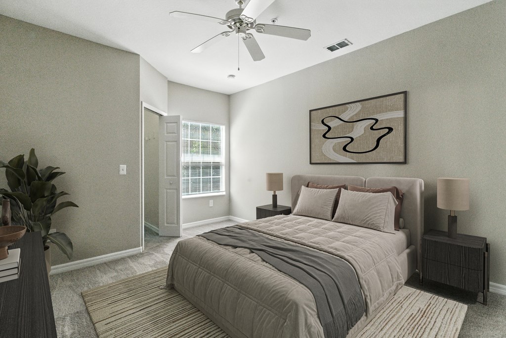 A bedroom with a large bed and a ceiling fan.