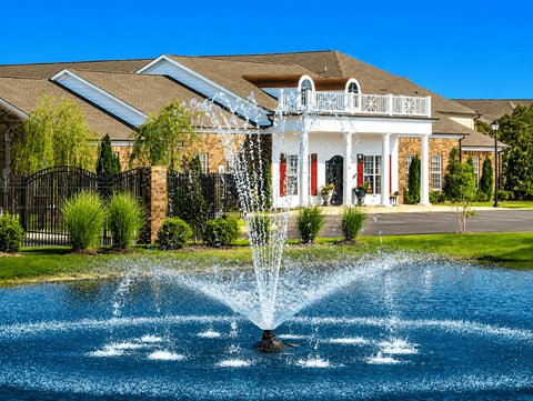 A house with a water fountain in front of it.