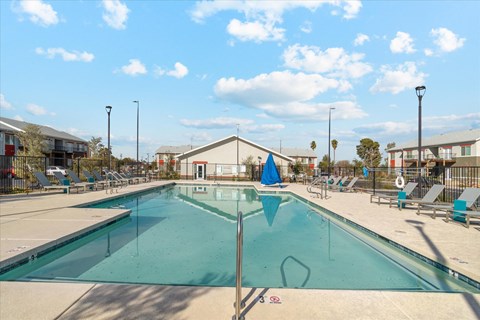 Rectangular swimming pool with lounge chairs and clubhouse at Sunland Flats Apartments, Phoenix