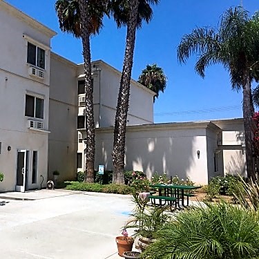 a building with a table and palm trees in front of it